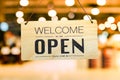 A business sign that says Ã¢â¬ËOpenÃ¢â¬â¢ on cafe or restaurant hang on door at entrance.